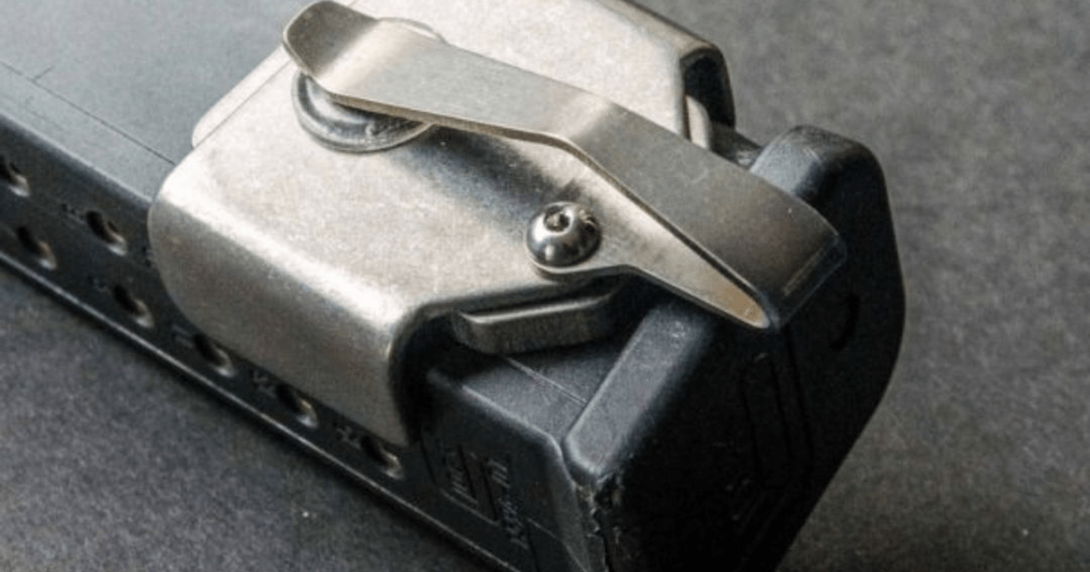 A closeup of a titanium NeoMag magentic pocket extra magazine holder with a magazine connected.