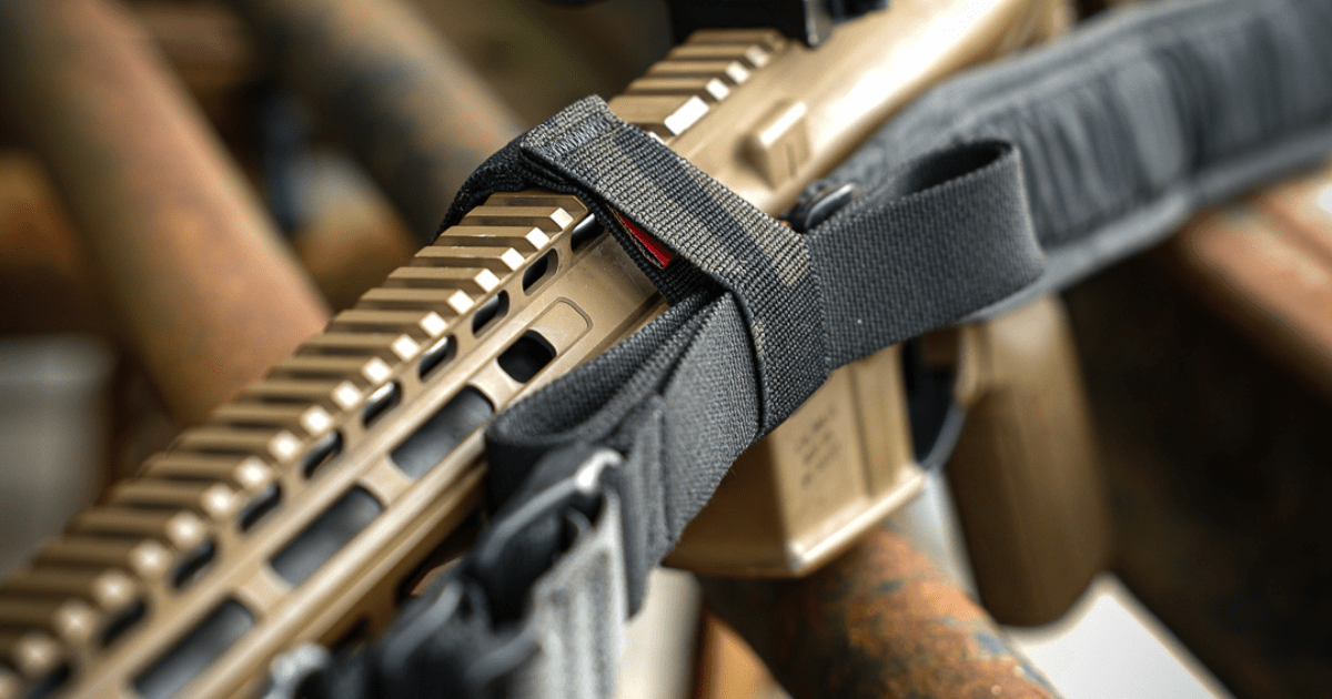A brown rifle with its sling staged using NeoMag's Sentry Strap.