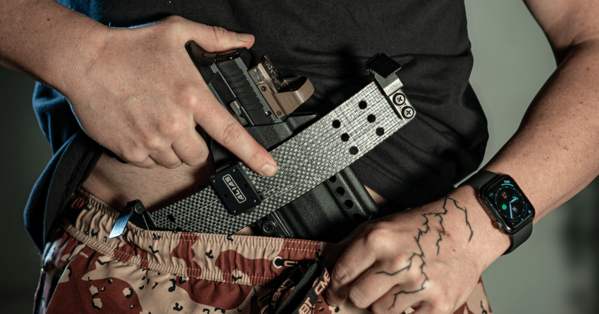 A man using the Alias system by NeoMag to carry concealed with a tucked in shirt.