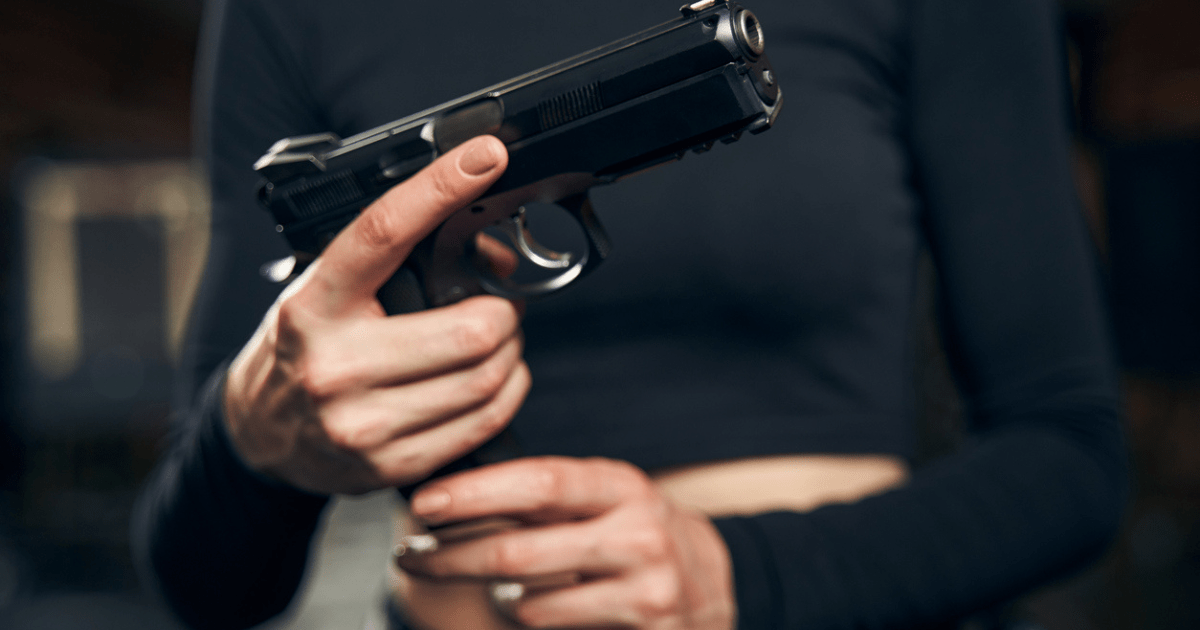A woman loading her handgun to start shooting practice.